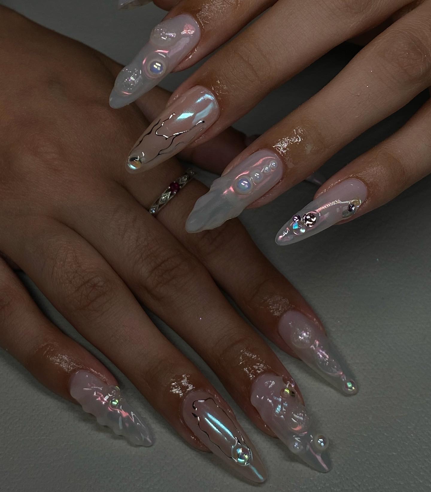 Iridescent chrome stiletto nails with crystal accents by Rita
