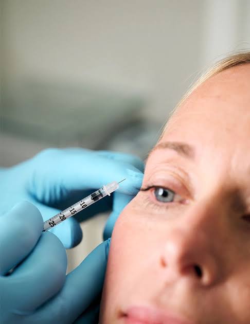 Close-up of a certified injector administering a precise injectable treatment near the eye