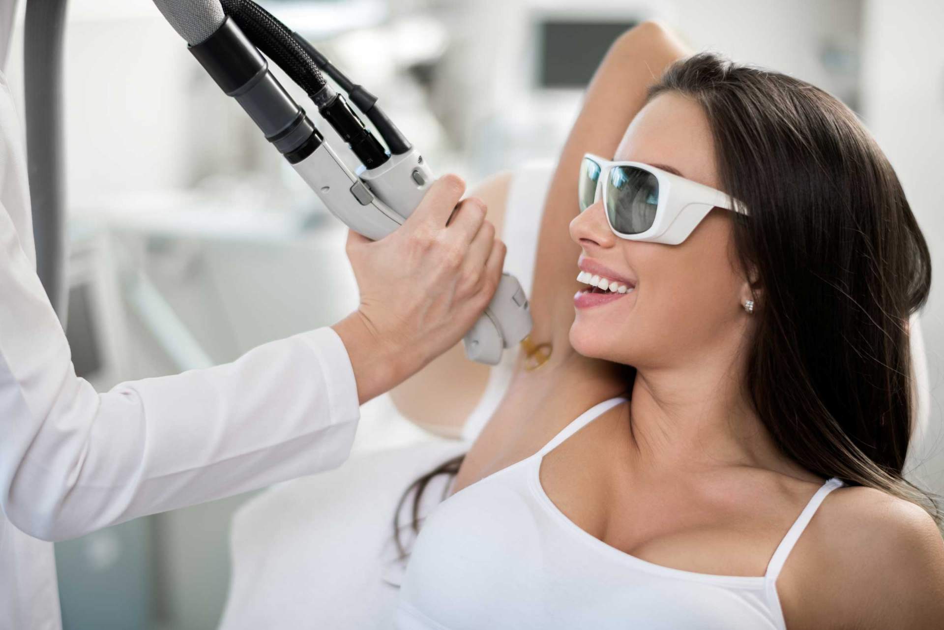Woman receiving laser hair removal treatment on underarm